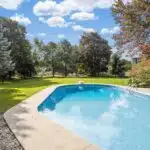 a large swimming pool in a backyard surrounded by trees