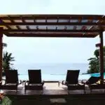 photo of four loungers under gazebo facing swimming pool